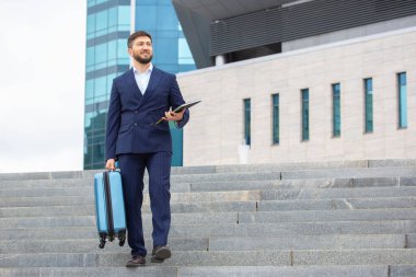 Başarılı iş adamı, ofis iş merkezinin arka planına doğru iniyor.