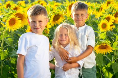 Mutlu yakışıklı çocuklar çiçek açan bir tarlada duruyor.