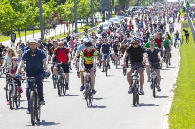 KHARKIV, UKRAINE - 23 Mayıs 2021: Farklı yaşlarda insanlar bir sütunla bisiklet sürerler şehir caddesi boyunca