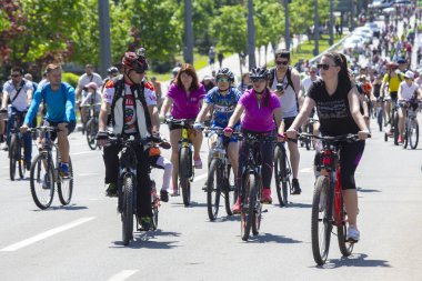 KHARKIV, UKRAINE - 23 Mayıs 2021: Farklı yaşlarda insanlar bir sütunla bisiklet sürerler şehir caddesi boyunca