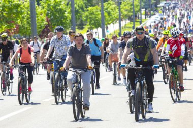 KHARKIV, UKRAINE - 23 Mayıs 2021: Bir sütun içinde insanlar şehir caddesi boyunca bisiklet sürerler.