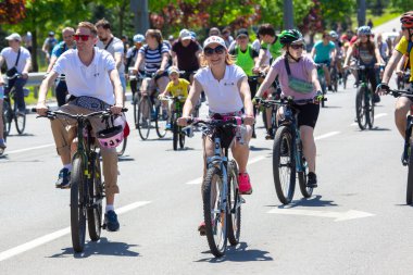 KHARKIV, UKRAINE - 23 Mayıs 2021: Farklı yaşlarda insanlar bir sütunla bisiklet sürerler şehir caddesi boyunca