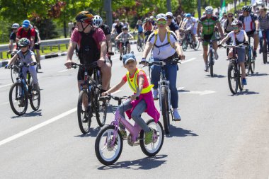 KHARKIV, UKRAINE - 23 Mayıs 2021: Farklı yaşlarda insanlar bir sütunla bisiklet sürerler şehir caddesi boyunca