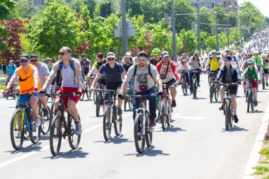 KHARKIV, UKRAINE - 23 Mayıs 2021: Bir sütun içinde insanlar şehir caddesi boyunca bisiklet sürerler.