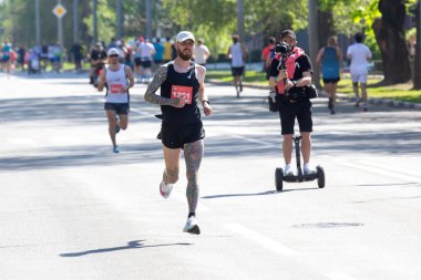 KHARKIV, UKRAINE - 16 Mayıs 2021: Kharkiv Half Marathon. Bir maratona katılan koşucular bir şehir sahnesinde bir mesafe koşuyor.