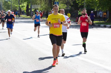 KHARKIV, UKRAINE - 16 Mayıs 2021: Kharkiv Half Marathon. Bir maratona katılan koşucular bir şehir caddesinde bir mesafe koşuyorlar.