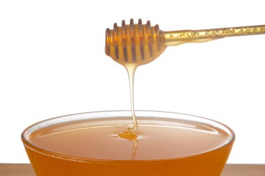 Beyaz arka planda şeffaf bir plakaya damlayan taze bal. organik vitamin sağlıklı gıdalar