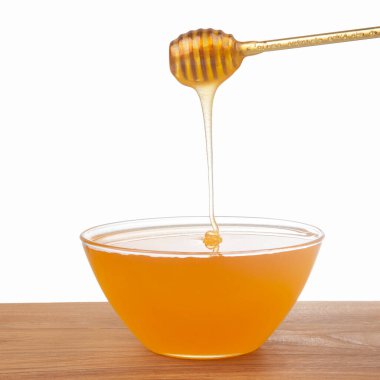Beyaz arka planda şeffaf bir plakaya damlayan taze bal. organik vitamin sağlıklı gıdalar