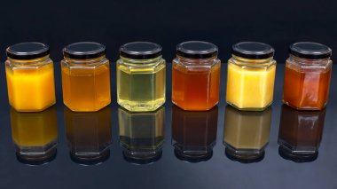 Farklı tipte ve taze çiçek rengi olan altıgen kavanozlar. Yaşam ve sağlık için vitamin gıdası