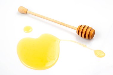 Beyaz arka planda taze bal dökülmüş kaşık. organik vitamin yiyeceği