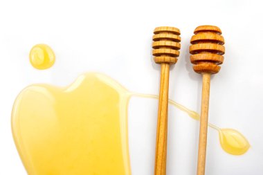 Beyaz arka planda taze bal dökülmüş kaşık. organik vitamin yiyeceği