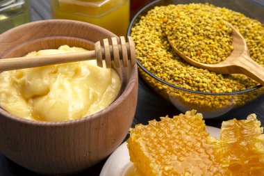 Farklı çeşitlerde taze çiçek balı, polen ve ahşap arka planda kaşıkları olan bal peteği. Organik Vitamin Sağlıklı Gıda