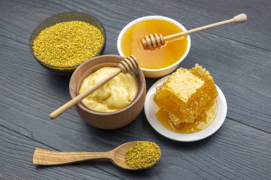 Farklı çeşitlerde taze çiçek balı, polen ve ahşap arka planda kaşıkları olan bal peteği. Organik Vitamin Sağlıklı Gıda