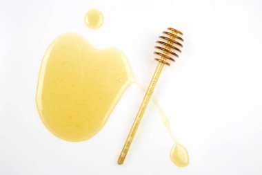 Beyaz arka planda taze bal dökülmüş kaşık. organik vitamin yiyeceği