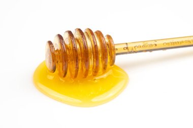 Beyaz arka planda taze bal dökülmüş kaşık. organik vitamin yiyeceği