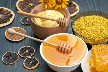 Taze çiçek, bal, polen ve tahta arka planda kaşıkları olan bal peteği. Organik Vitamin Sağlıklı Gıda