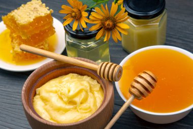 Farklı türde taze çiçek balı, polen ve ahşap zemin üzerinde kaşıklar olan bal peteği. Organik Vitamin Sağlıklı Gıda