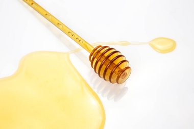 Beyaz arka planda taze bal dökülmüş kaşık. organik vitamin yiyeceği