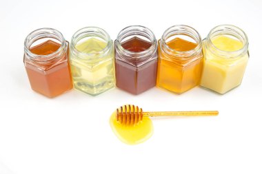 Farklı bal çeşitleriyle kavanozların arka planında taze bal ve polen olan kaşık. organik vitamin yiyeceği