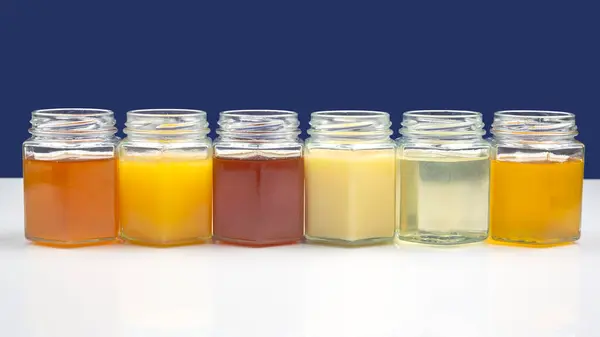 Sklenice Různými Druhy Barvami Medu Bílém Modrém Pozadí Organický Vitaminový — Stock fotografie