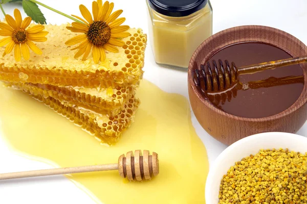 Fresh flower honey in a wooden bowl, spoon, pollen and honeycomb. vitamin food for health and life