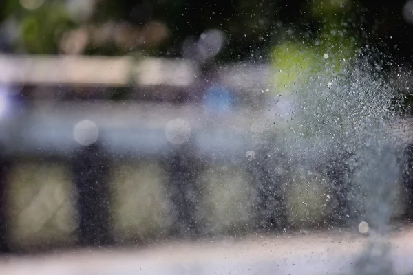 Брызги фонтана на размытом фоне — стоковое фото