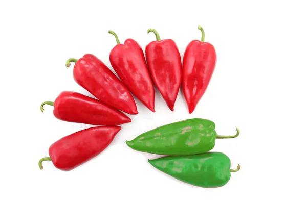 Dois verde brilhante e seis pimentas vermelhas doces em um fundo branco — Fotografia de Stock