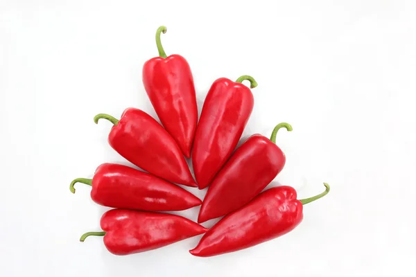 Seven bright red sweet peppers on a white background — Stock Photo, Image