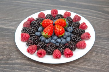 Ahududu, yaban mersini ve böğürtlen beyaz tabakta. Vitamin ve Diyet Yemekler