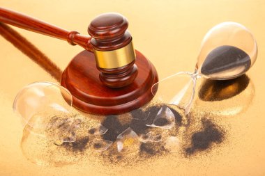 Tahta bir tokmak kırık bir kum saatinin yanında duruyor, siyah kumlar dökülüyor. Altın arka plan, hukuki süreçte zamanın aciliyetini ve kırılganlığını vurguluyor.