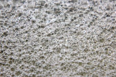 Baloncuklar büyüleyici, desenli, altıgen desenli, ışığı güzel yansıtan bir yüzey yaratırlar. Yakın plan, sabun filminin hassas yapısını ve şeffaf niteliklerini gözler önüne seriyor..