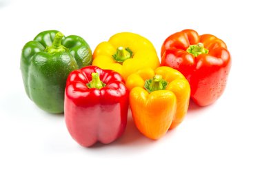 Yeşil, kırmızı, sarı ve turuncu renkli beş dolma biberden oluşan canlı bir koleksiyon beyaz arka planda yan yana oturur..