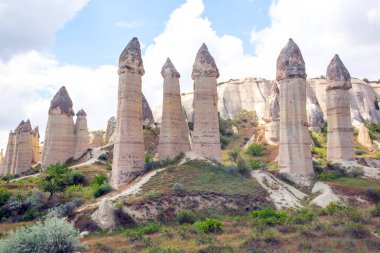 Türkiye 'nin Cappadocia kentindeki peri bacaları, gür tepelerin ortasında ve mavi gökyüzünün altındaki kaya oluşumları, bölgenin eşsiz jeolojisini ve zengin mirasını gözler önüne seriyor..