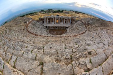 Türkiye 'nin Hierapolis kentindeki tiyatronun antik kalıntılarını araştıran ziyaretçiler, olağanüstü mimari ve panoramik manzaralara hayran kaldılar..