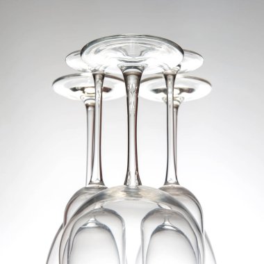 Dört şarap kadehi sanatsal olarak baş aşağı dizilmiş, narin arka planlarına karşı narin tasarımlarını vurguluyorlar. Bu düzenleme gözlüklerin hem şeklini hem de işçiliğini vurgular..