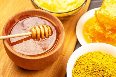 Altın balla dolu ahşap bir kase küçük bir polen tabağının yanında oturur ve bir kase daha krema yayılır. Sıcak renkler çağdaş bir mutfakta davetkar bir atmosfer yaratıyor..