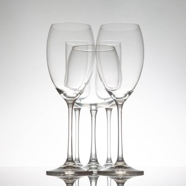 Benzersiz hatlara sahip beş şık şarap kadehi. Yansımaları parlak bir yüzeyde yansıtılıyor. Üst düzey ayarlar için ince gri bir arkaplan üzerine kurulmuş..