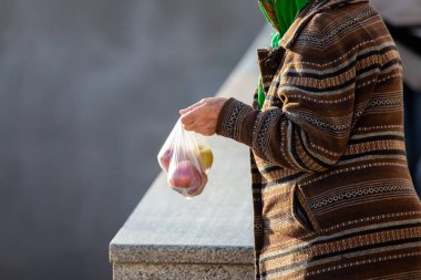 Zavallı yaşlı kadın bir çanta elma satıyor. Yaşlıların ticareti ve hayatta kalması