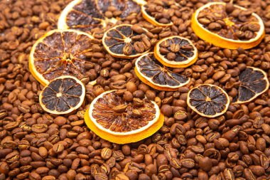 Kavrulmuş kahve çekirdeklerinin arasına yerleştirilmiş canlı bir portakal dilimleri sıcak, aromatik aromatik narenciye ve kahve dokuları oluşturur. kahve aroması ve tat tanımlayıcıları