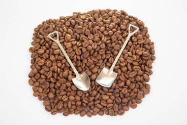 Kesişen paslanmaz çelik kürekler koyu kavrulmuş kahve çekirdekleri tabakası üzerinde, aşçılık ya da tarımsal ürünler için mükemmel.