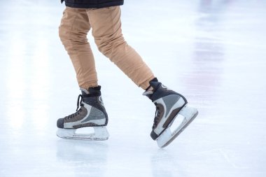 Buz pateni pistinde yuvarlanan birinin ayakları.