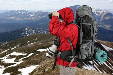 dürbün ile seyir Dağları yamacında kırmızı ceketli seyahat fotoğrafçı ile donatılmış