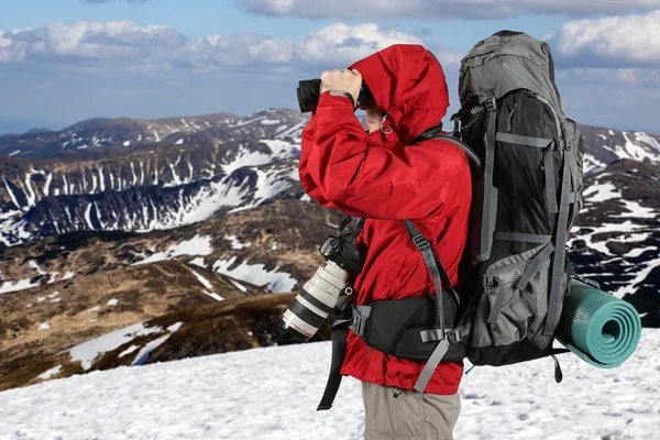 Фотограф-путешественник в красной куртке на склоне рта — стоковое фото