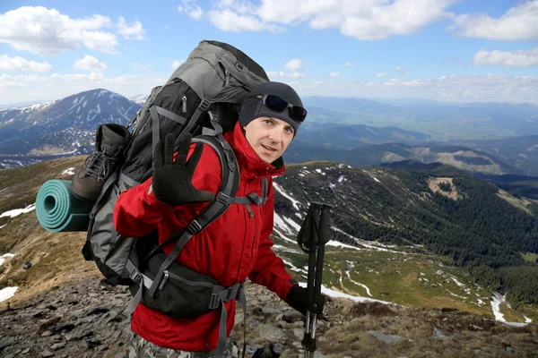Счастливый путешественник в красной куртке на склоне холма поднят — стоковое фото