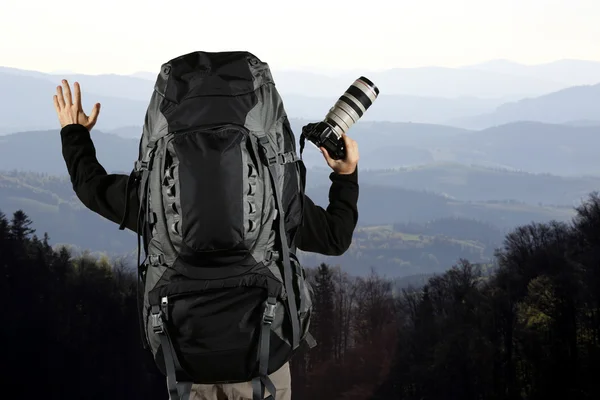 Cestovní batoh a ruce s kamerou — Stock fotografie