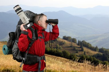 Kırmızı ceketli seyahat fotoğrafçı ile donatılmıştır