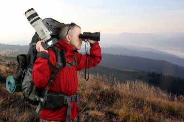 Kırmızı ceketli seyahat fotoğrafçı ile donatılmış
