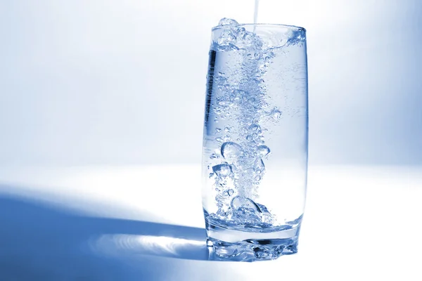 Víz ömlött az átlátszó üveg, a buborékok a levegő — Stock Fotó