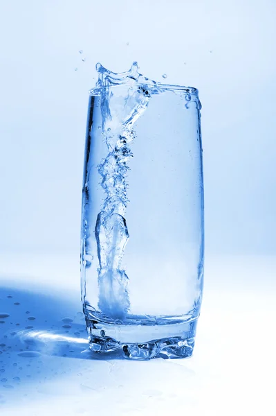 L'eau coulant dans du verre transparent avec des bulles d'air — Photo