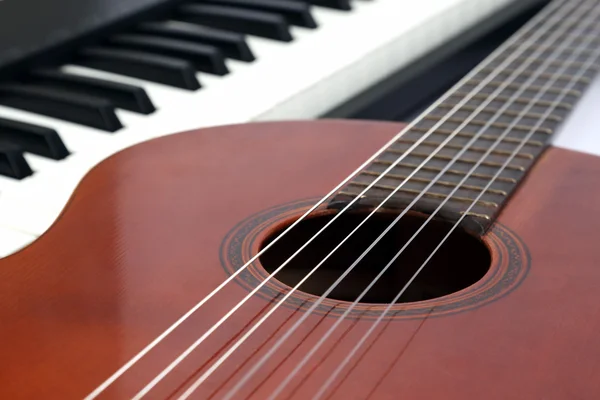 Klaviertasten und klassische Gitarre in Nahaufnahme auf weißem Hintergrund — Stockfoto